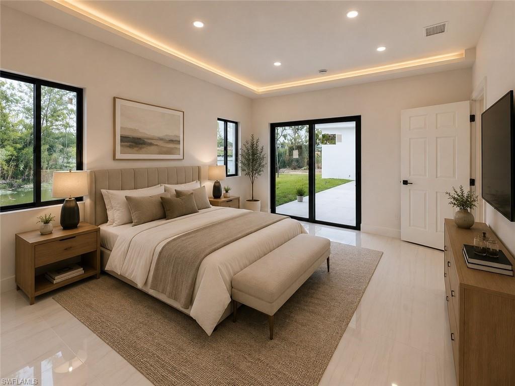 Spacious bedroom featuring gloss tile flooring and a tray ceiling with integrated lighting