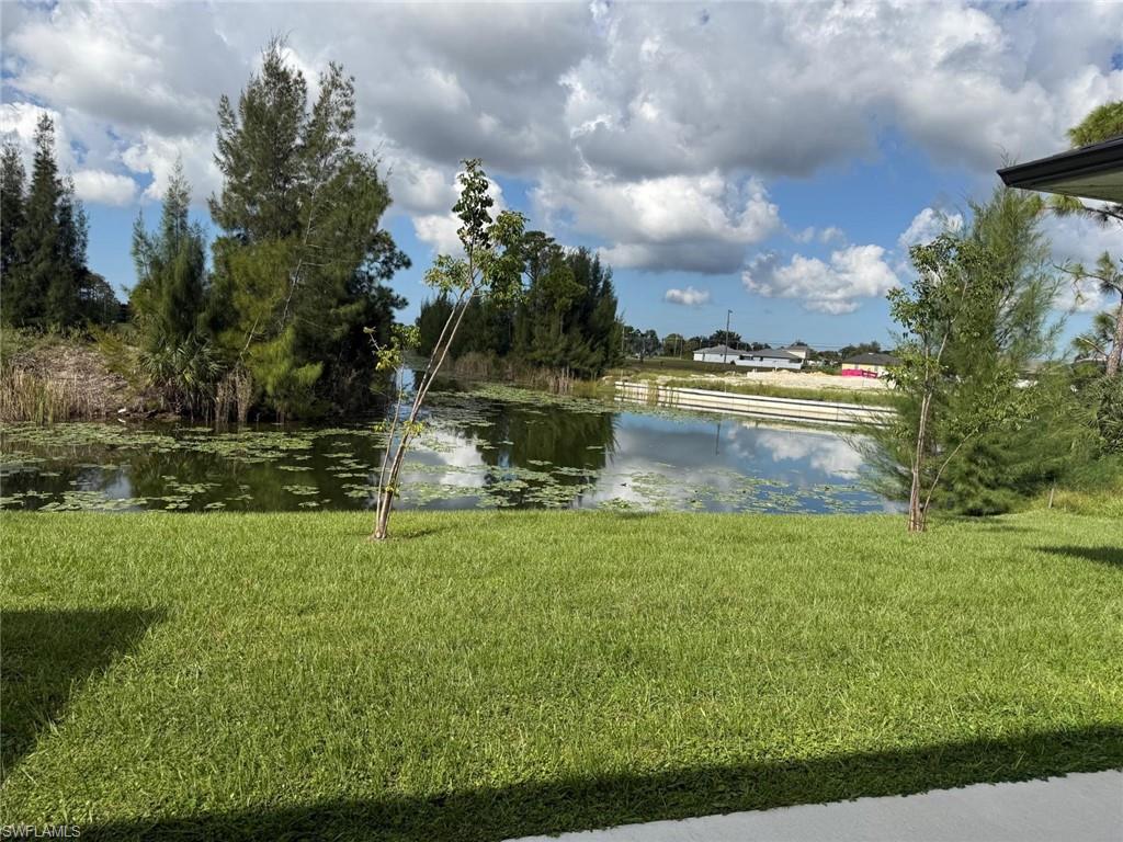 Expansive green lawn with water feature, mature trees, and natural landscaping
