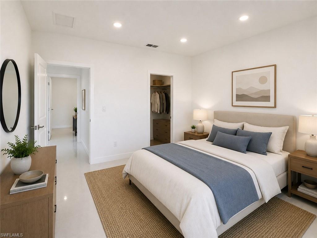 Light-filled bedroom featuring recessed lighting, a walk-in closet with built-in storage, and pale flooring