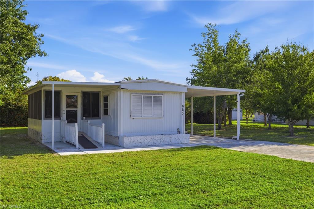 Single-story residence featuring a screened porch, covered carport, and a concrete driveway
