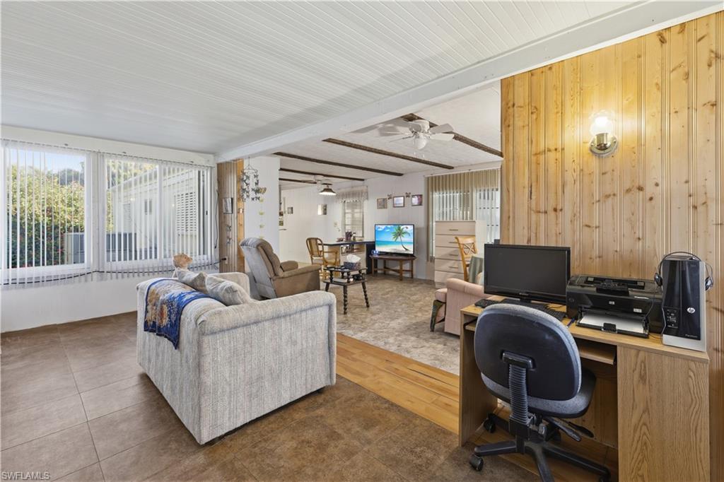 Living space featuring varied flooring, including tile and wood-finish, with wood paneling