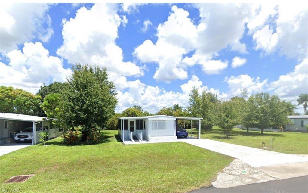 Single-story residence featuring a carport, screened front porch, and a concrete driveway