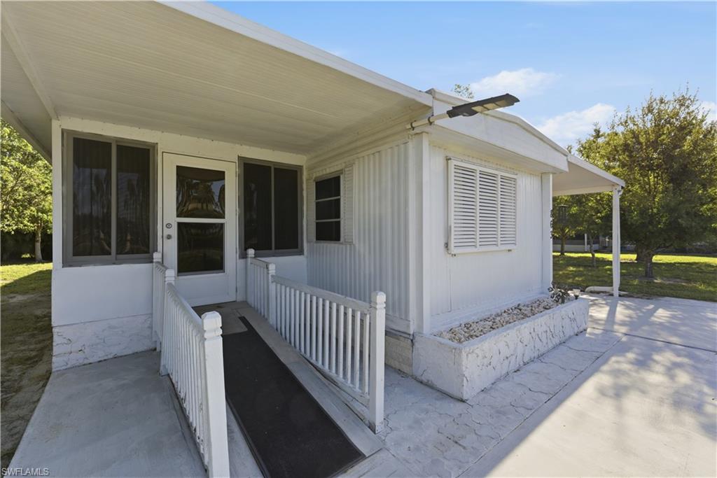 Covered front entry featuring a ramp and white railing