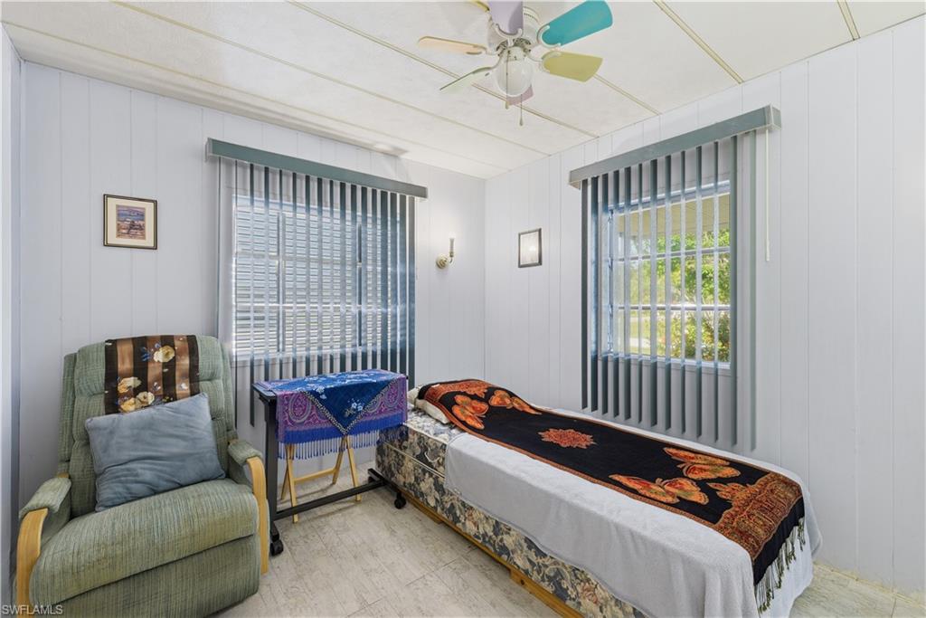 White paneled walls and ceiling with two windows featuring vertical blinds