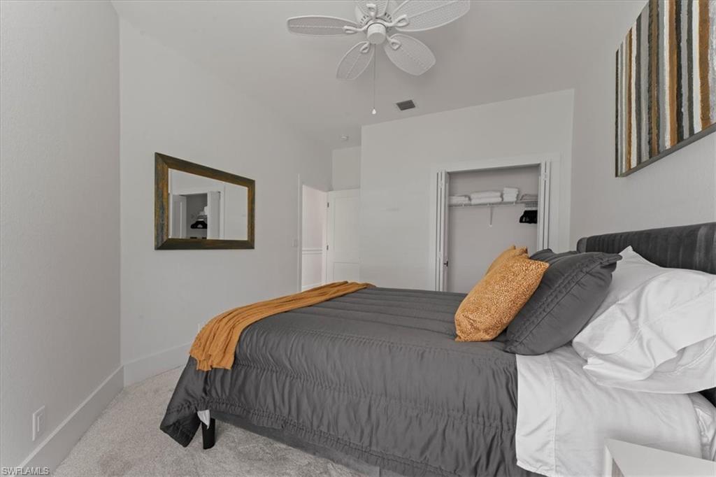 Carpeted bedroom with baseboards, a ceiling fan, and a closet