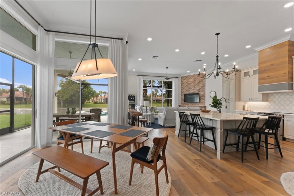 Dining area with a chandelier, light wood-style flooring, recessed lighting, and ornamental molding