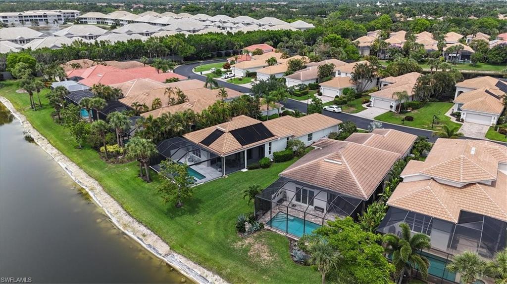 Aerial view of residential area featuring a nearby body of water and a pool area