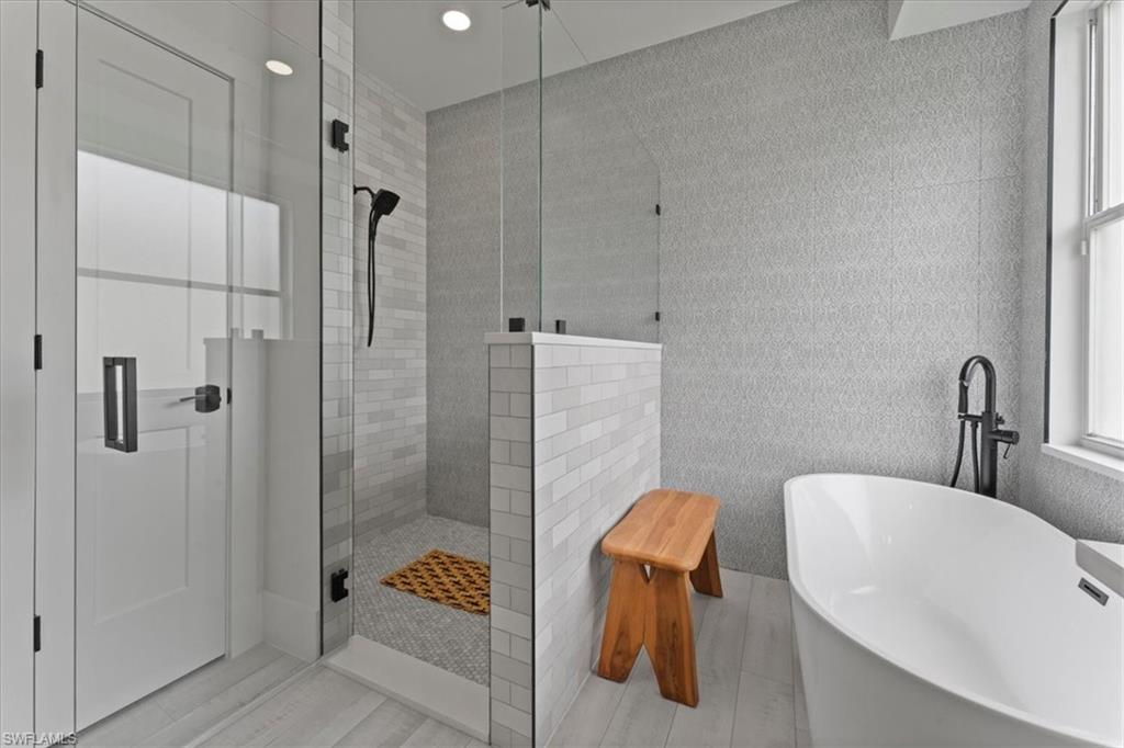 Full bathroom featuring a tile shower, a freestanding tub, and recessed lighting