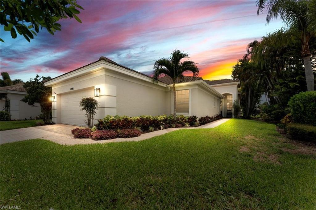 Single story home featuring stucco siding, driveway, a front lawn, and a garage