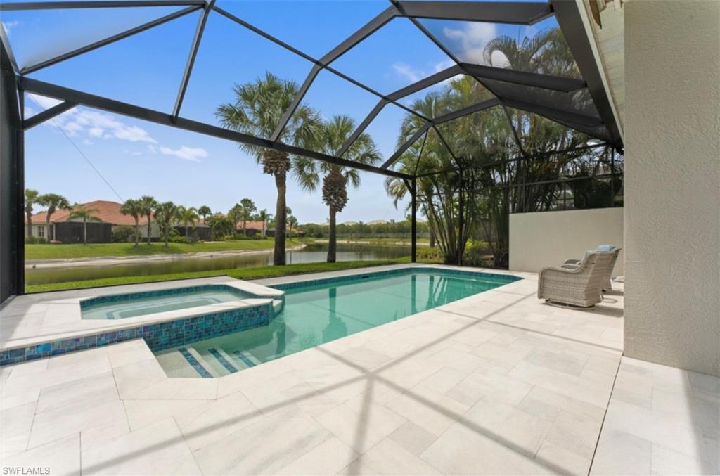 View of swimming pool with a patio, a water view, and a lanai
