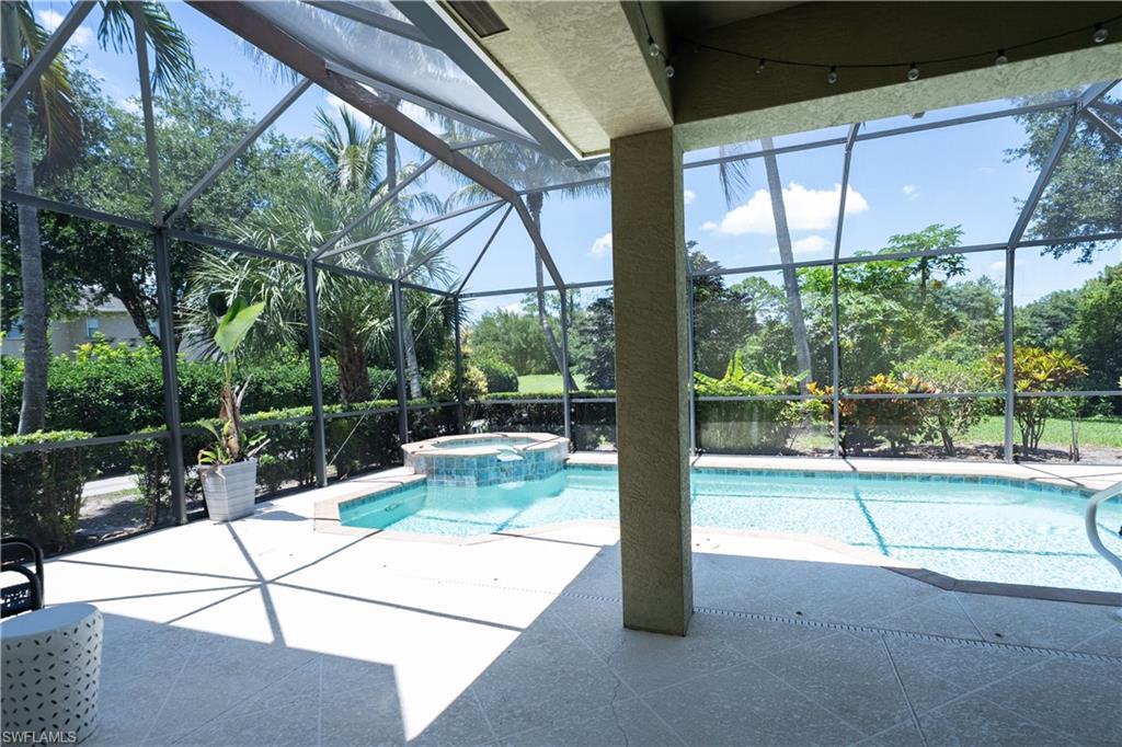 Screened-in outdoor living space with a pool and integrated spa