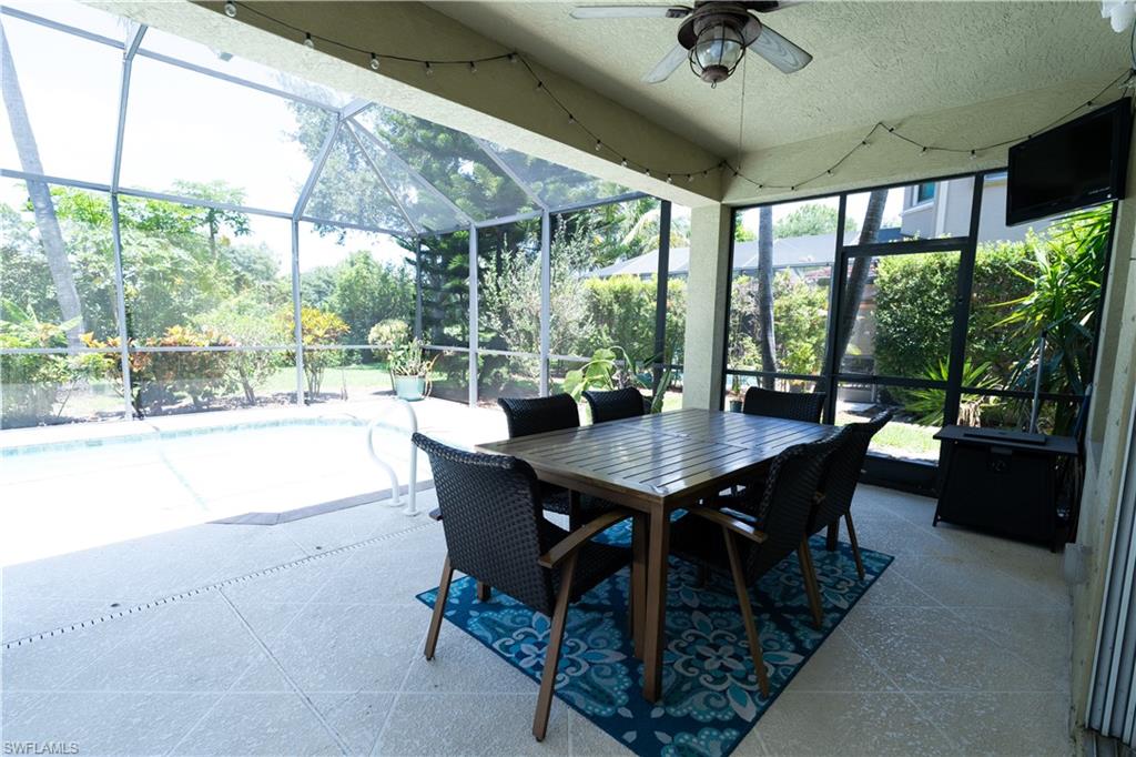 Screened patio with a built-in ceiling fan, string lighting, and tiled flooring