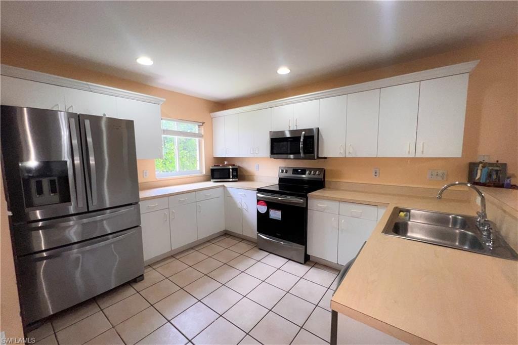Kitchen featuring white cabinetry and light-toned countertops