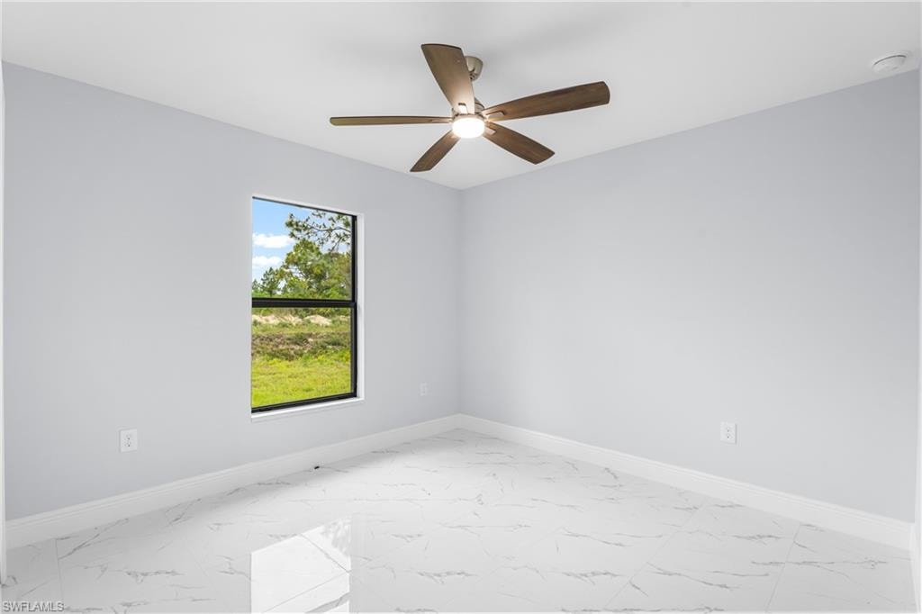 Spacious room featuring a ceiling fan with light, a single window with a dark frame, and light-toned walls