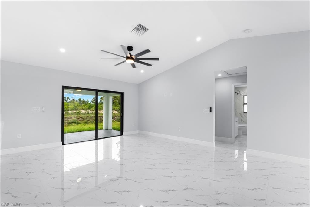 Spacious interior featuring marble-look tile flooring, vaulted ceilings, and a contemporary ceiling fan with integrated lighting