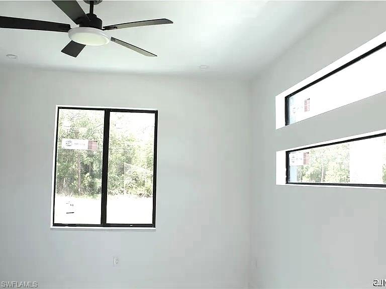 Room featuring a contemporary ceiling fan with integrated lighting, a large rectangular window, and two horizontal transom windows