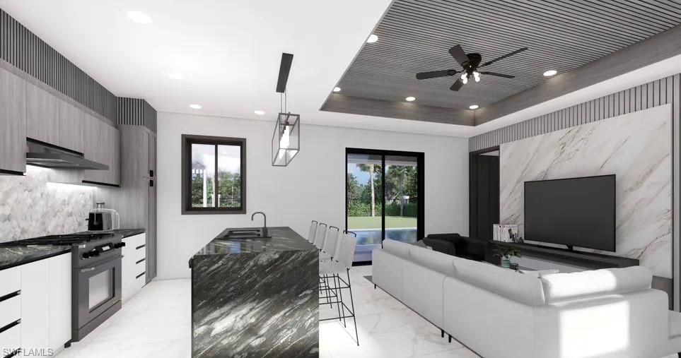 Contemporary kitchen and living area featuring a stone island with seating, a full-size range, recessed lighting, and a detailed ceiling design with a ceiling fan