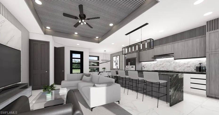 Open-concept living area featuring a kitchen island with a waterfall countertop, integrated bar seating, and a linear pendant light fixture