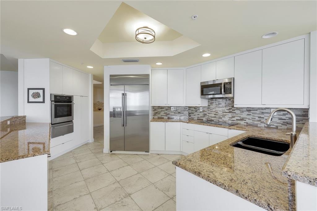 Well-designed kitchen with generous counter space and white European-style cabinetry, perfect for everyday cooking.