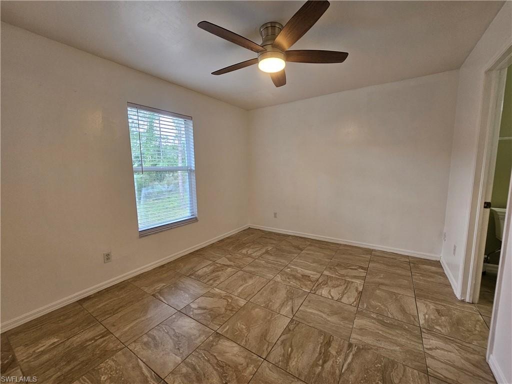 Room featuring large format tile flooring, a window with horizontal blinds, and a ceiling fan with integrated lighting