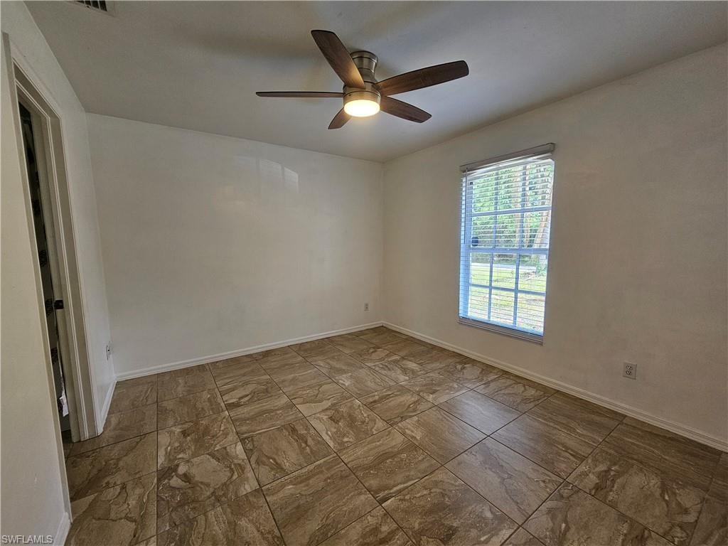 Room featuring large format tile flooring, a window with horizontal blinds, and a ceiling fan with integrated lighting