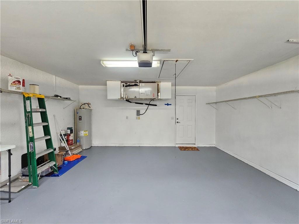 Garage featuring a painted concrete floor, built-in overhead storage, and wall-mounted shelving