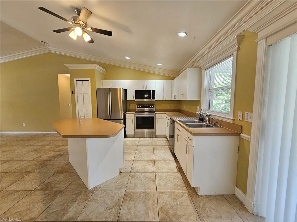 Kitchen featuring stainless steel appliances, white cabinetry, light-toned countertops, and tile flooring