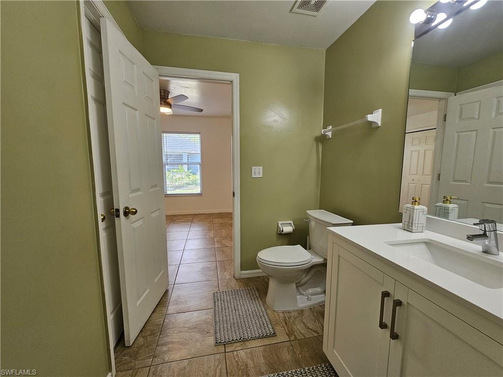 Bathroom featuring a white vanity with a rectangular sink, a contemporary chrome faucet, and bronze-finish cabinet pulls