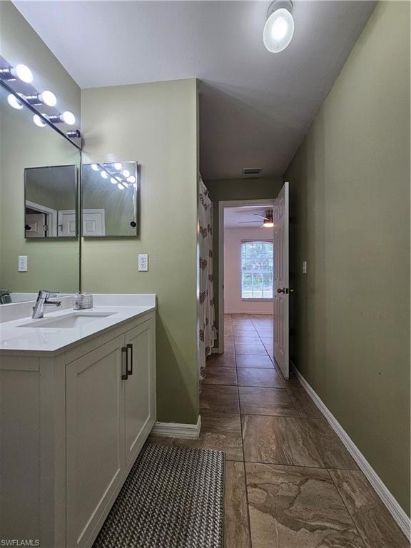 Bathroom vanity featuring a white countertop, undermount sink, and chrome faucet