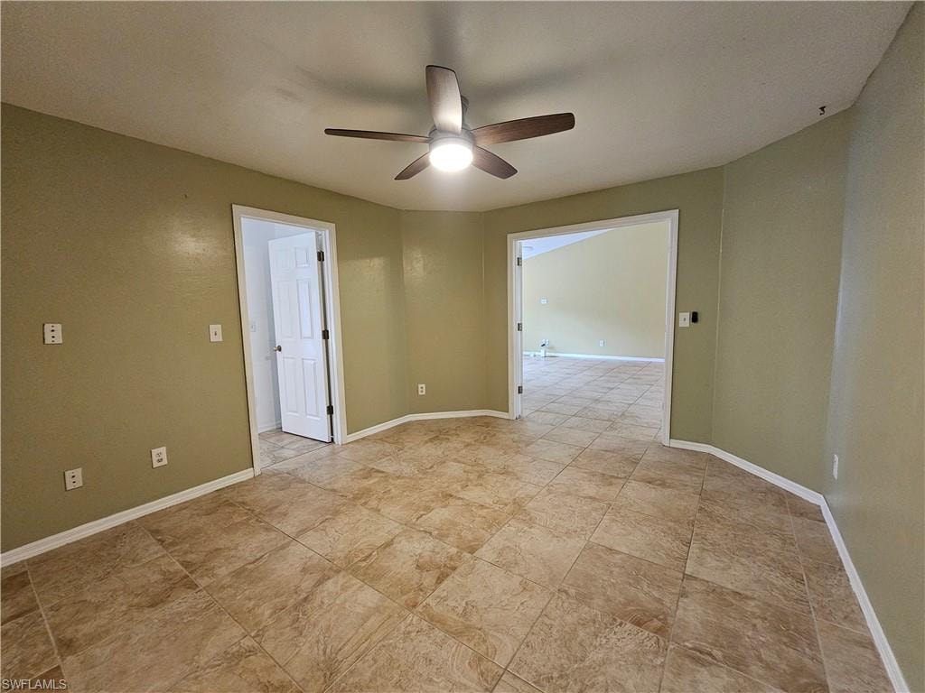 Spacious room featuring neutral tile flooring, a ceiling fan with integrated lighting, and olive-toned walls