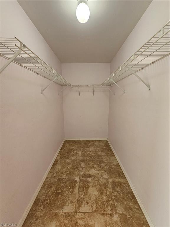 Spacious walk-in closet featuring wire shelving and hanging rods