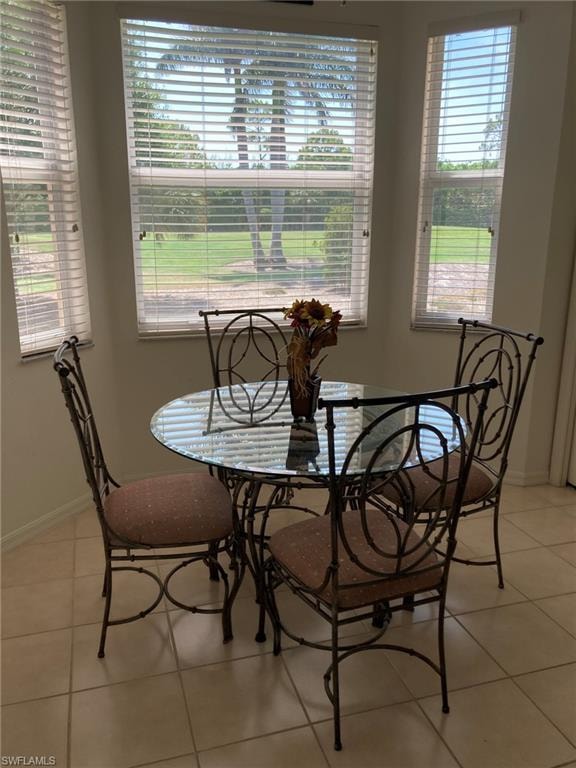 Dining area with light tile patterned floors and baseboards