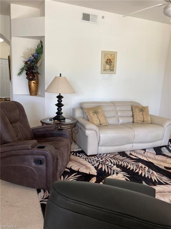 Carpeted living room with arched walkways