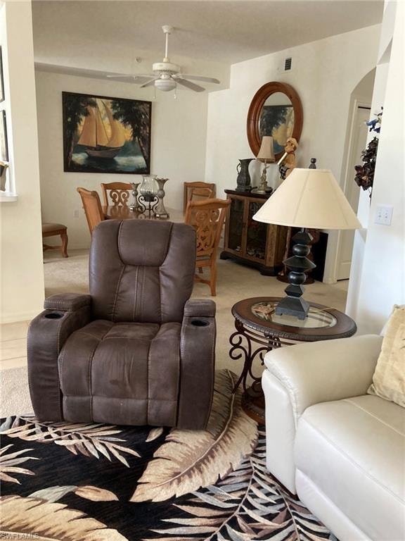 Living area featuring a ceiling fan and arched walkways