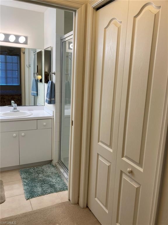 Bathroom with vanity, a stall shower, and tile patterned flooring