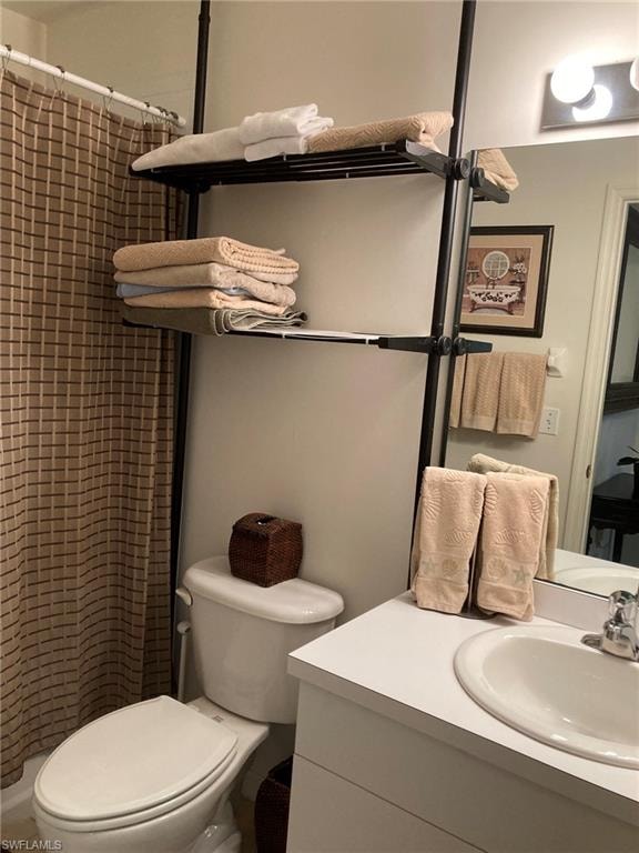 Full bathroom featuring toilet, tiled shower, and vanity
