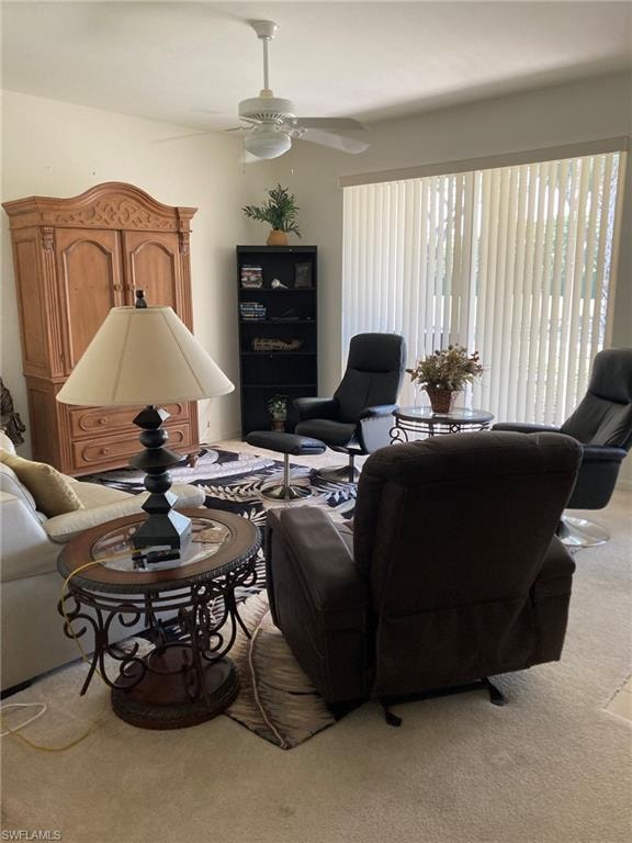 Carpeted living room with a ceiling fan