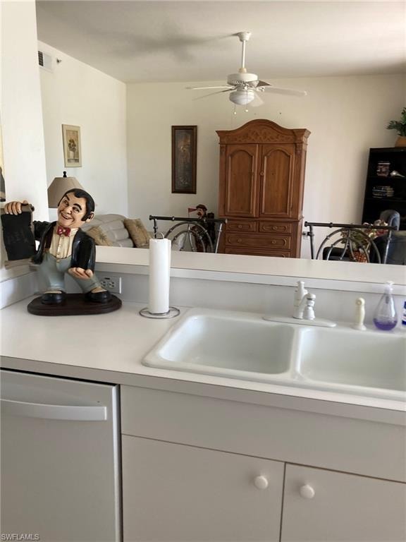 Kitchen featuring stainless steel dishwasher, light countertops, a sink, and ceiling fan