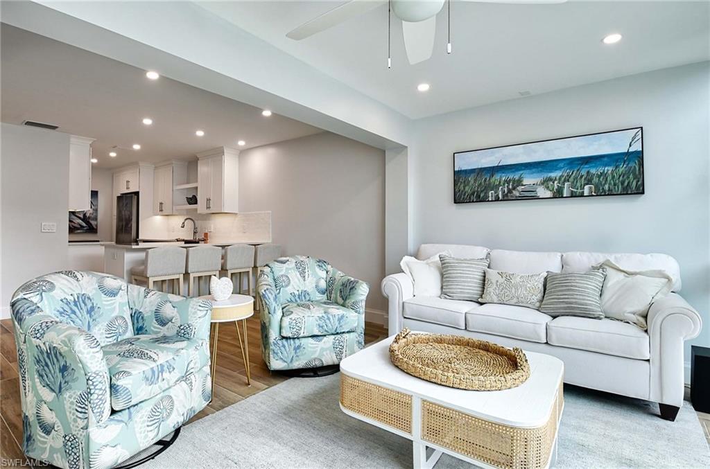 Living room with ceiling fan, light wood-type flooring, and sink
