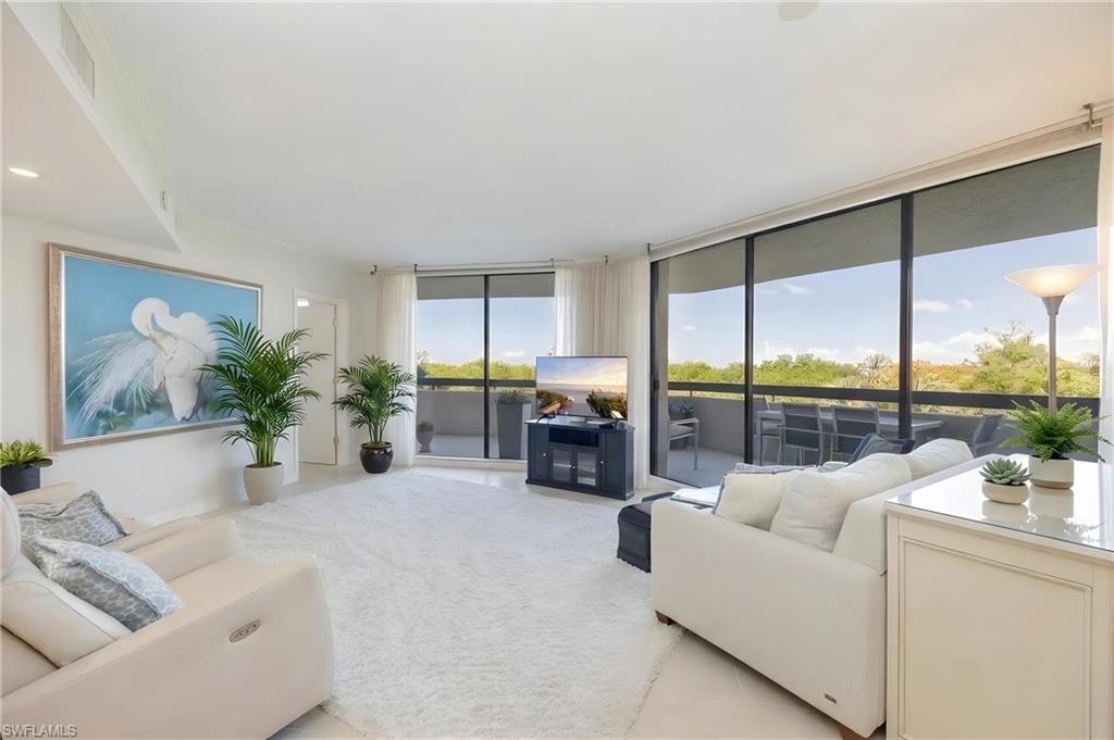 Bright living area featuring expansive glass sliding doors opening to a private balcony
