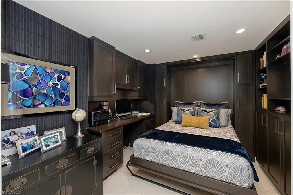 Integrated wall unit with a Murphy bed, built-in desk, and surrounding cabinetry