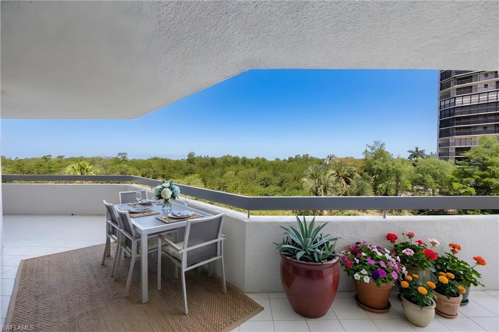 Open-air balcony featuring a tiled floor and a perimeter wall with a dark railing