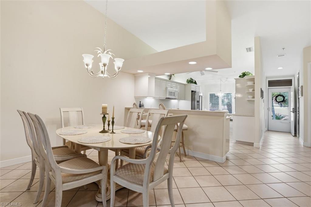 Formal dining area featuring a vaulted ceiling and a decorative chandelier