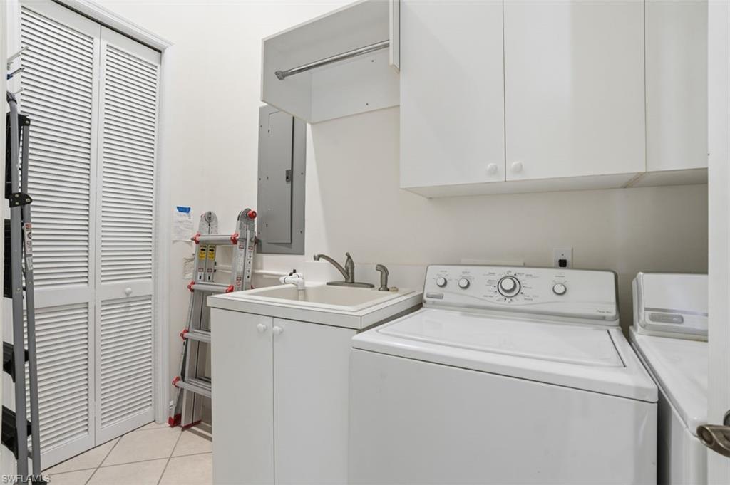 Laundry room with full sized washer and dryer, plus a laundry tub