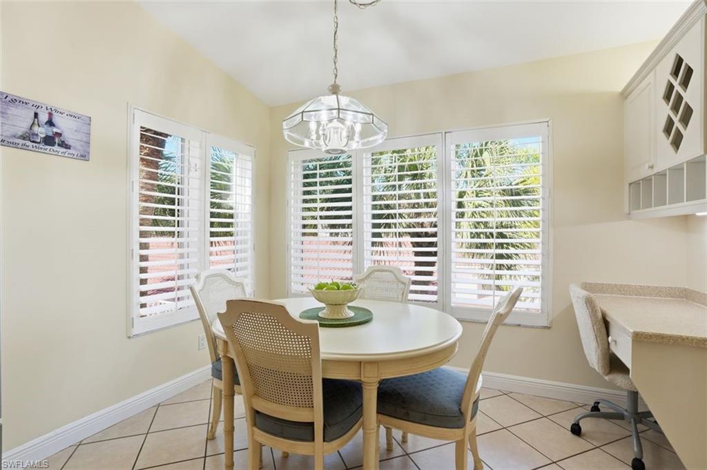 Eat-in kitchen/breakfast area featuring white plantation shutters and a desk