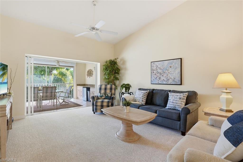 Spacious living area featuring a vaulted ceiling and a ceiling fan