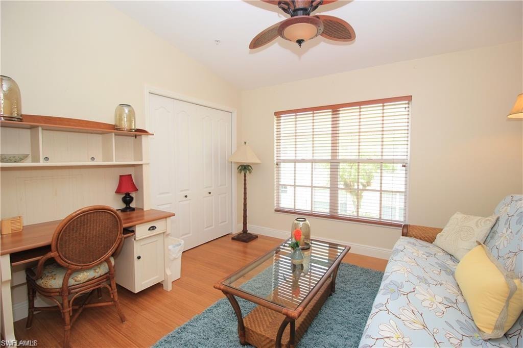 Living room with light wood-type flooring, lofted ceiling, and ceiling fan