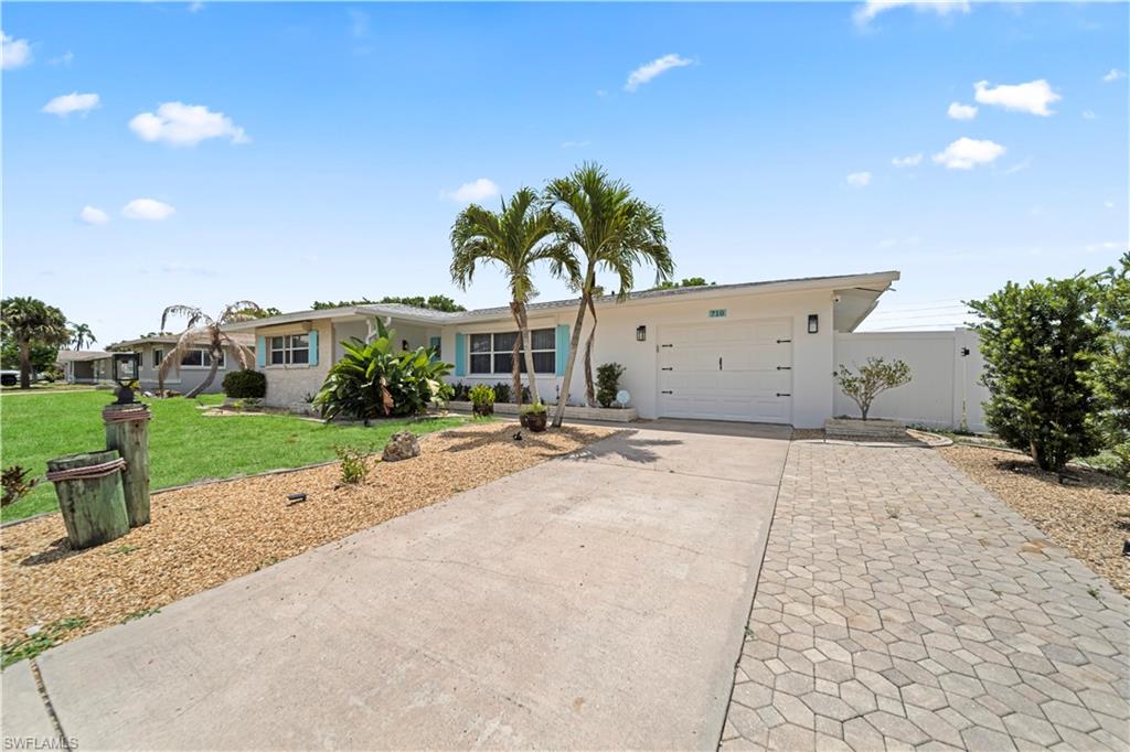 Single-story residence featuring a white stucco exterior with light blue window shutters