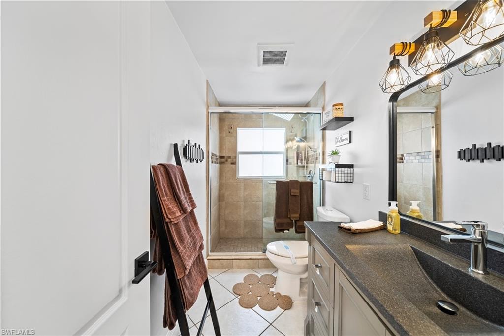 Bathroom featuring a vanity with an integrated sink, a rectangular mirror, and a three-light fixture with geometric cages