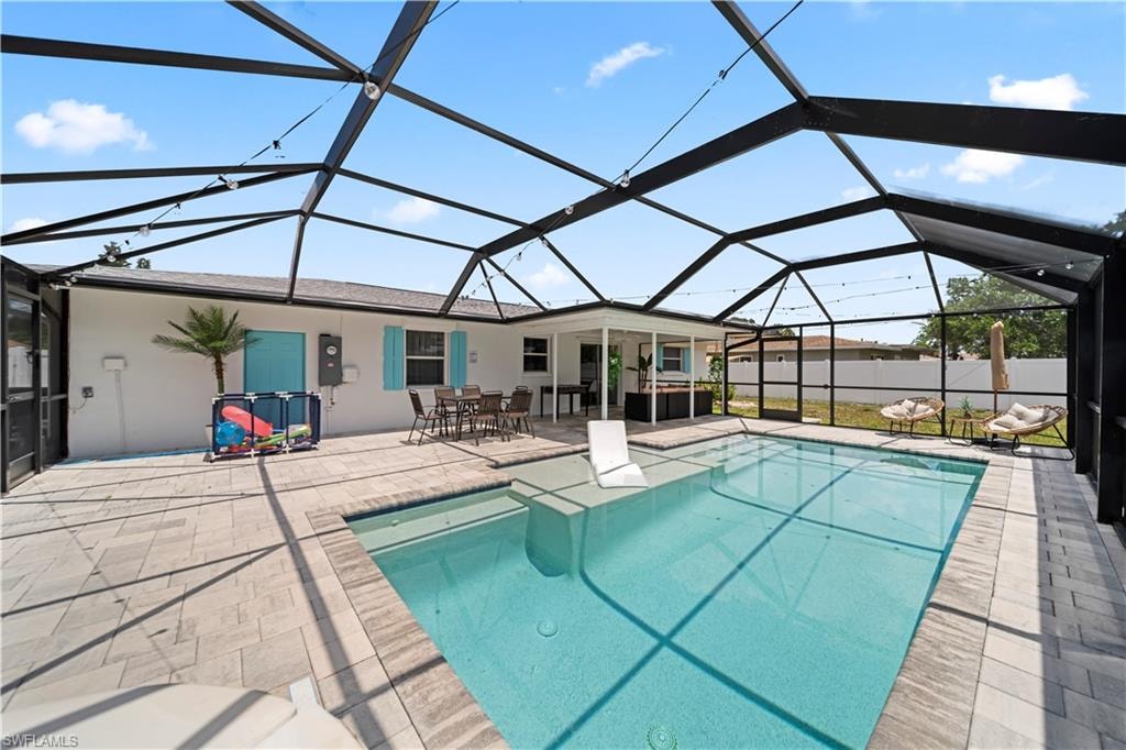 Screened swimming pool enclosure featuring a rectangular pool, paver deck, and covered patio area